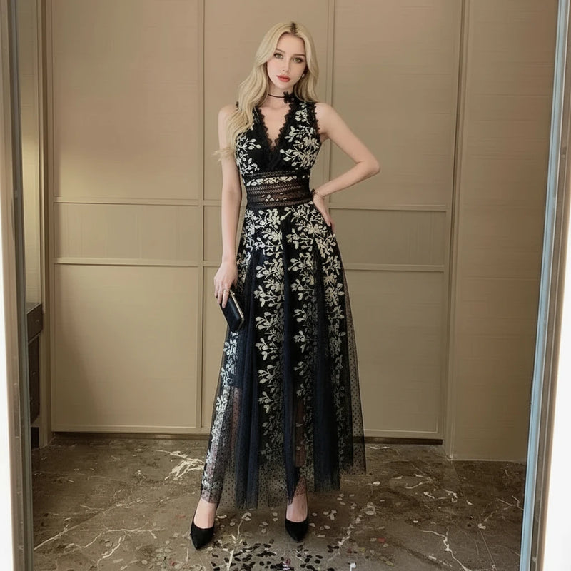 A model wearing a black mesh embroidered waistband dress with a V-neck collar and floral patterns.