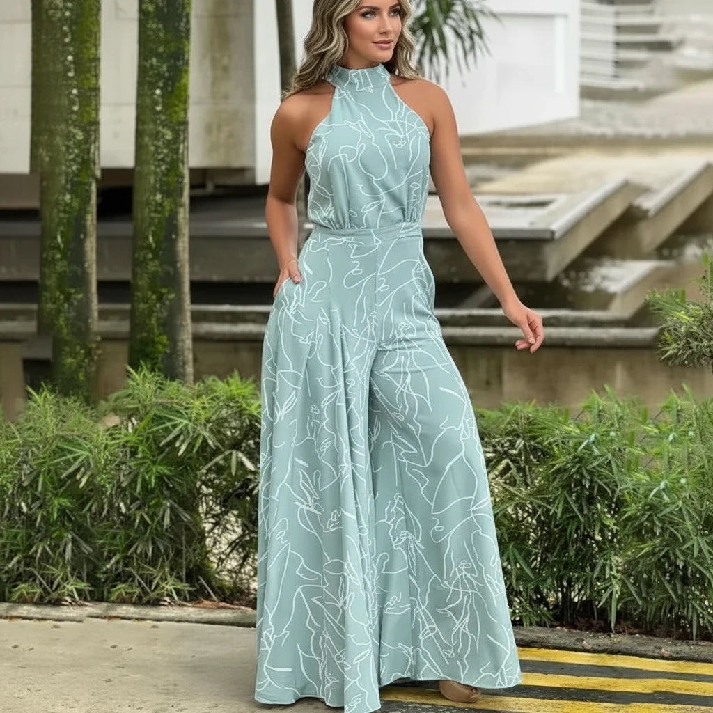 Woman wearing a light blue floral jumpsuit standing outdoors.
