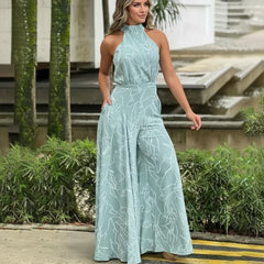 Woman wearing a light blue floral jumpsuit standing outdoors.