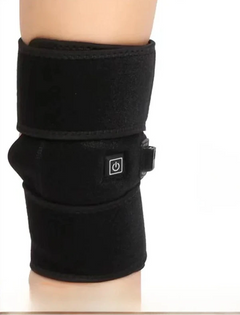 Black heated knee brace on a plain background