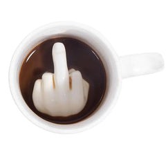 White ceramic mug with a middle finger design in a dark liquid on a white background