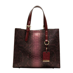 Brown/Redish textured handbag with a matching tag on a white background