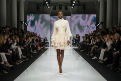 Beige dress with long sleeves and layered skirt on a white background