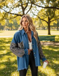 A woman wearing a blue plaid long-sleeve jacket with sequin detailing on the sleeves, paired with a white top and black pants.