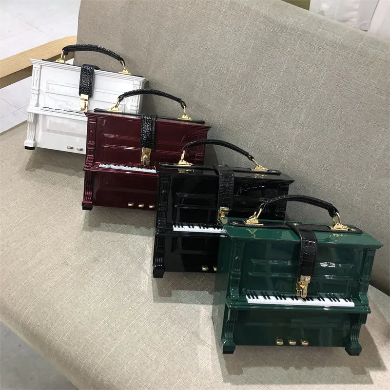 Set of piano-shaped handbags on a light gray surface.